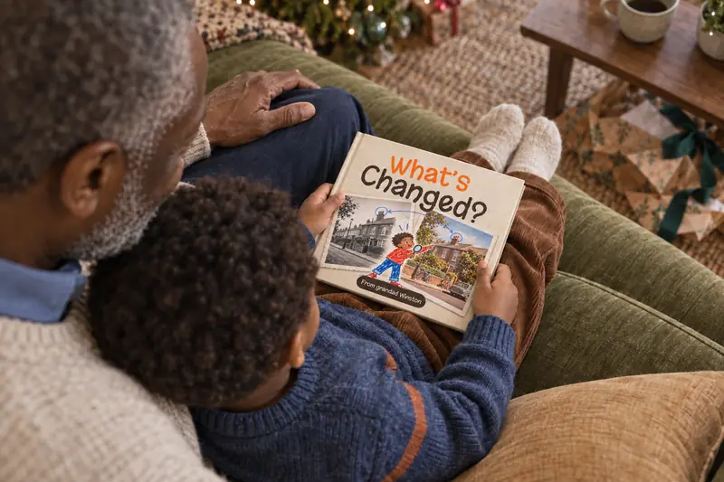The What's Changed? hardback held open, the child's own name printed on the cover.
